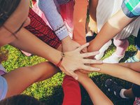 Eine Gruppe Menschen legt ihre Hände gemeinschaftlich aufeinander