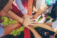 Eine Gruppe Menschen legt ihre Hände gemeinschaftlich aufeinander