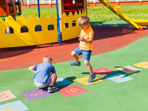 Zwei Kinder spielen Hüpfkästchen
