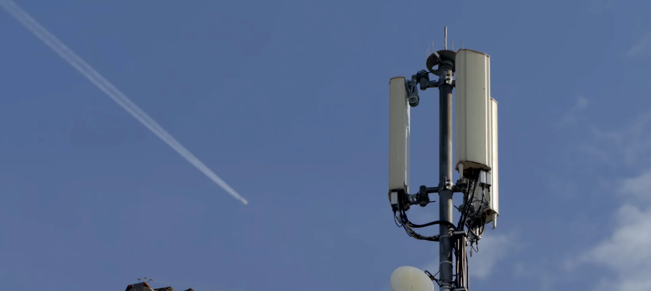 Ein Mobilfunkmast auf einem Hausdach