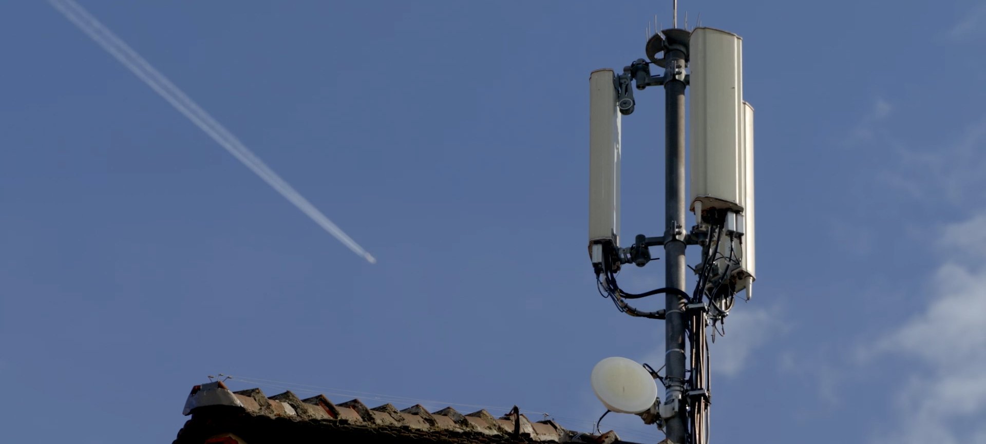 Ein Mobilfunkmast auf einem Hausdach
