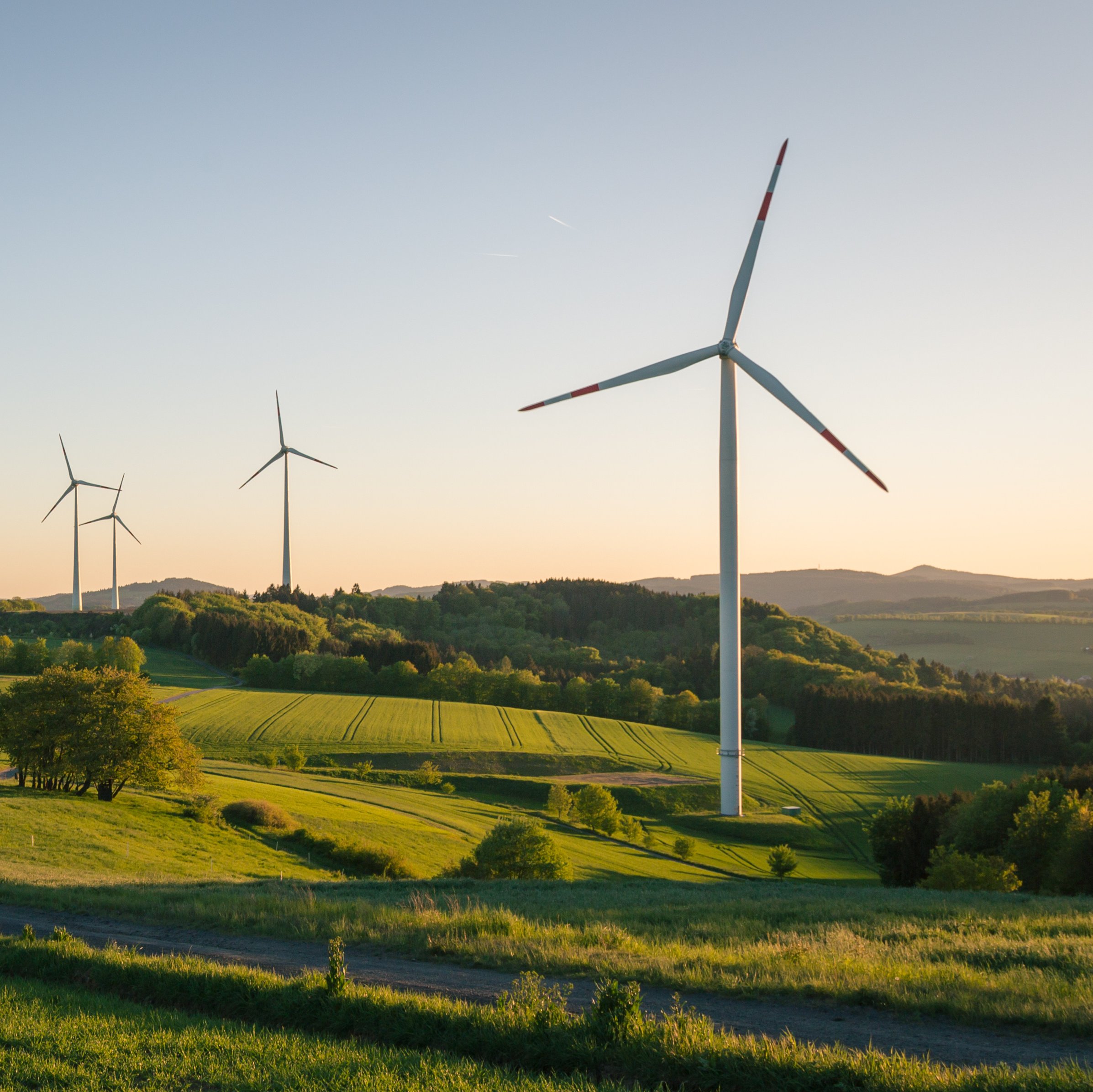 Mehrere Windkraftanlagen im Sonnenuntergang
