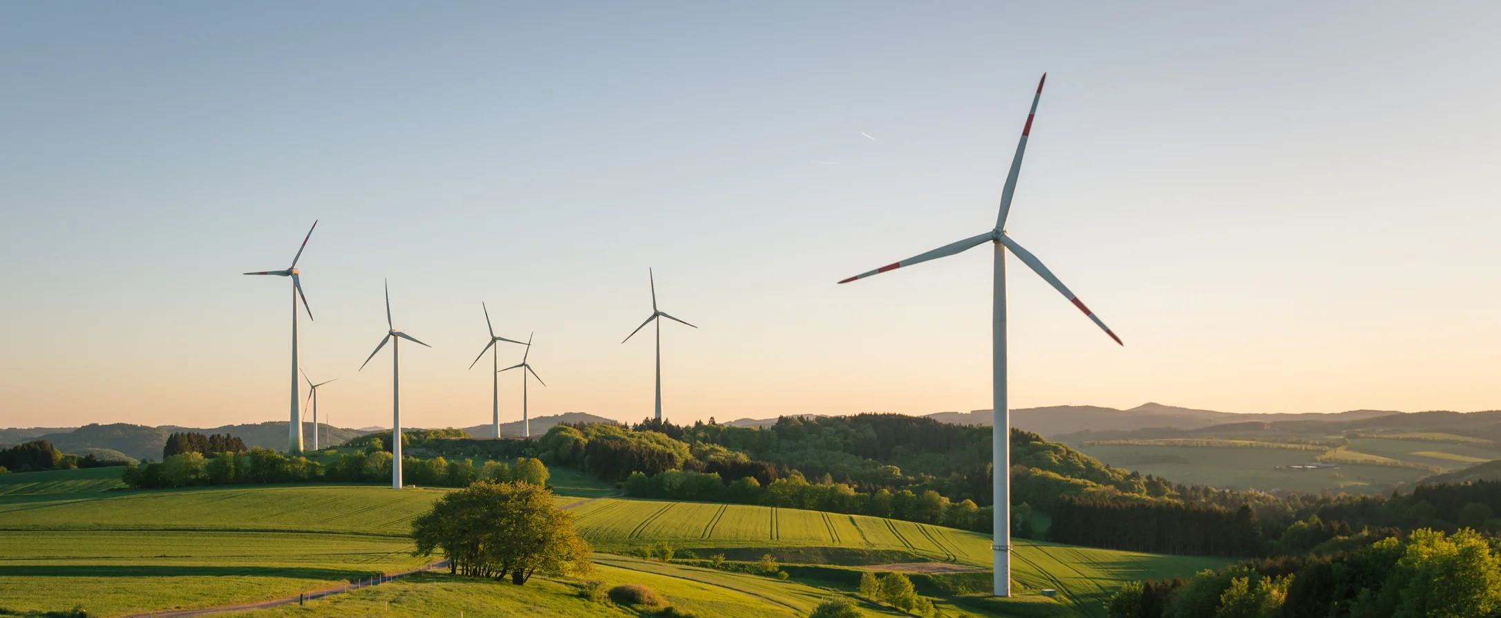 Mehrere Windkraftanlagen im Sonnenuntergang