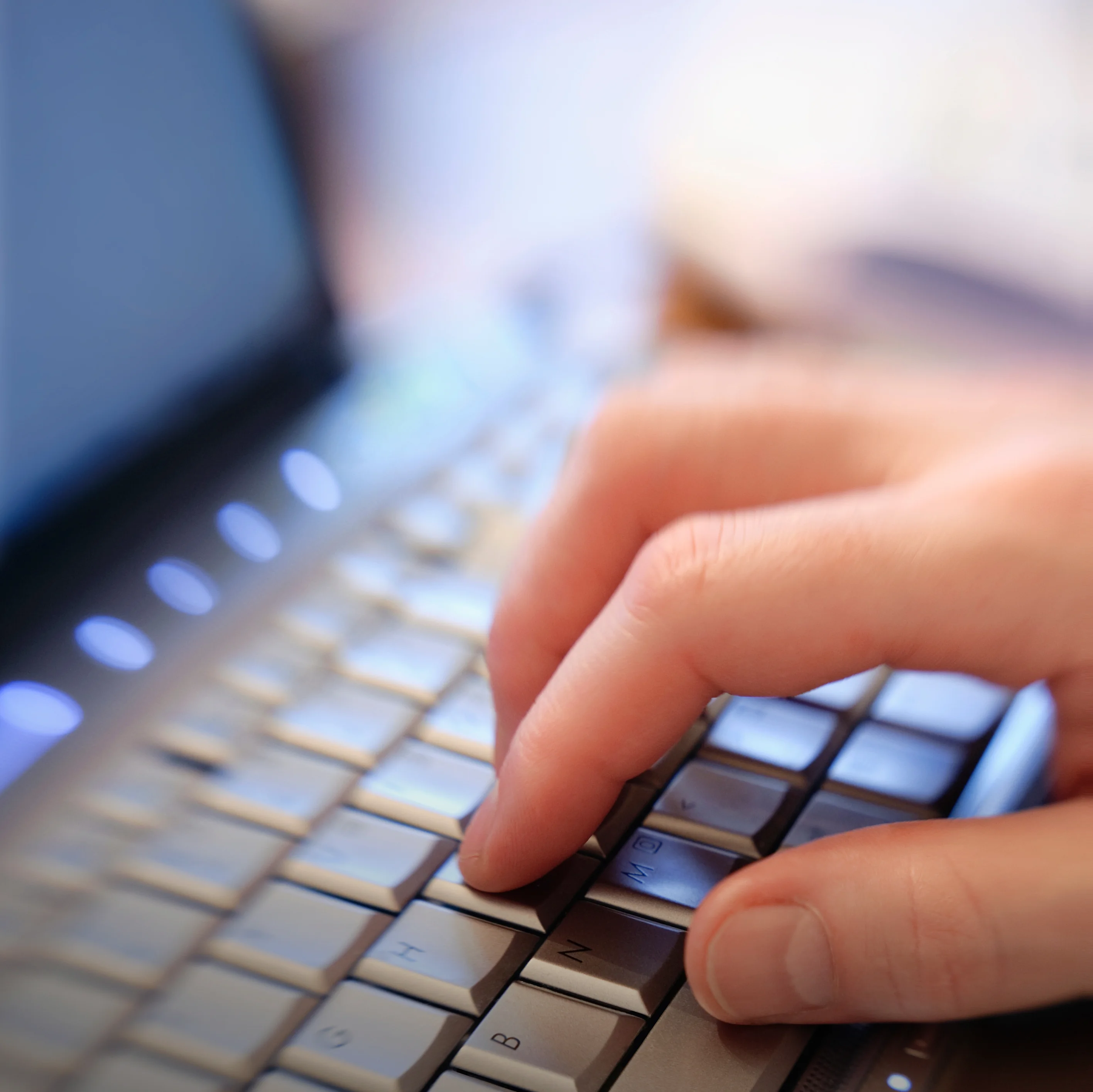 Eine Hand auf einem Laptop.