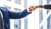 Zwei Menschen geben sich einen Faustgruß
