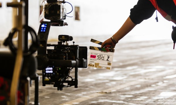 Filmklappe wird vor eine Filmkamera gehalten 