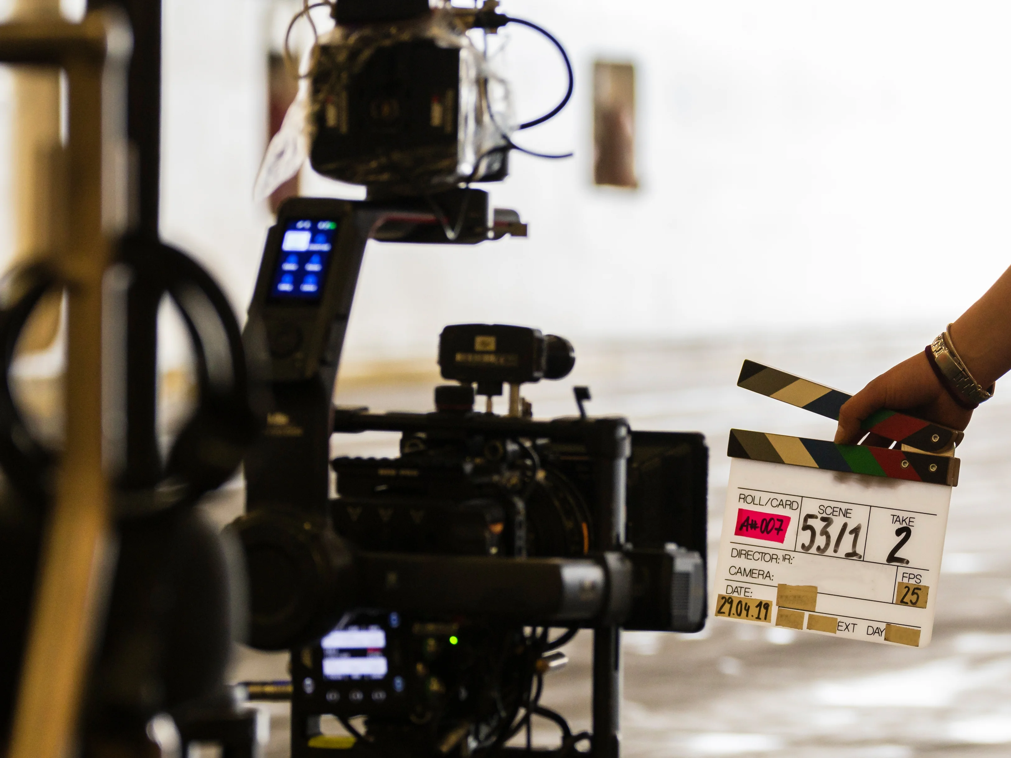 Filmklappe wird vor eine Filmkamera gehalten 