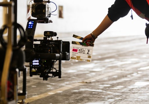 Filmklappe wird vor eine Filmkamera gehalten 
