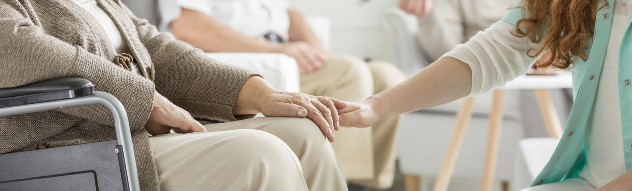 Ältere Person hält die Hand eines jüngeren Menschen