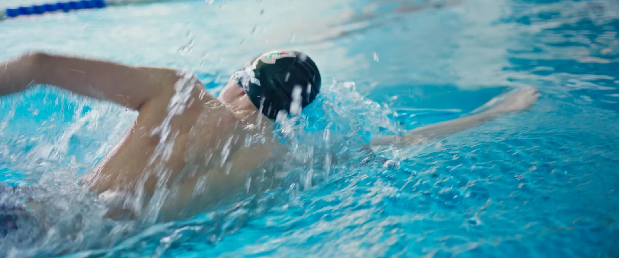 Ein Mann krault im Schwimmbecken