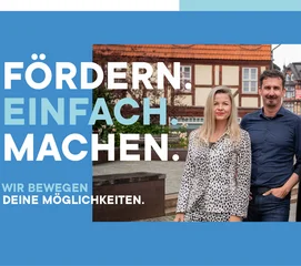 Ein Mann und zwei Frauen stehen vor Fachwerkhäusern in Wernigerode.