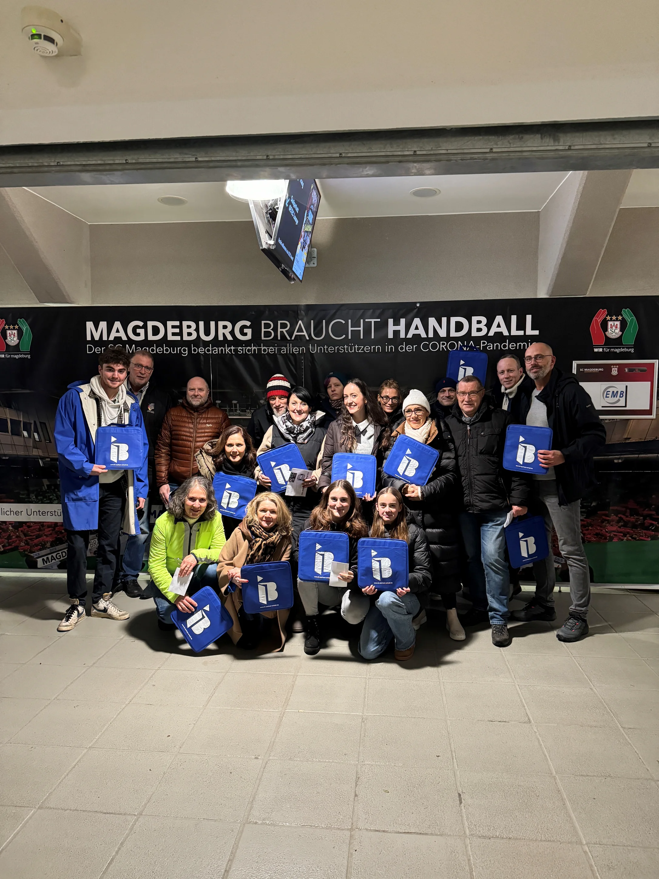Mitglieder des Verein verwaister Eltern und trauernder Geschwister mit IB-Logos in der Hand