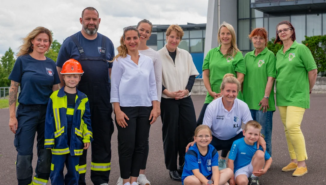 Ehrenamtliche, Männer, Frauen und Kinder, vor der Getec-Arena in Magdeburg.