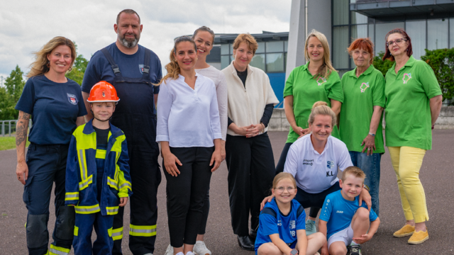Ehrenamtliche, Männer, Frauen und Kinder, vor der Getec-Arena in Magdeburg.