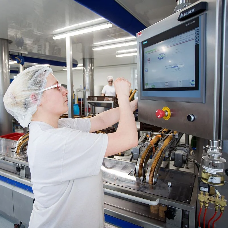 Eine Frau arbeitet an einer modernen Produktionsmaschine 