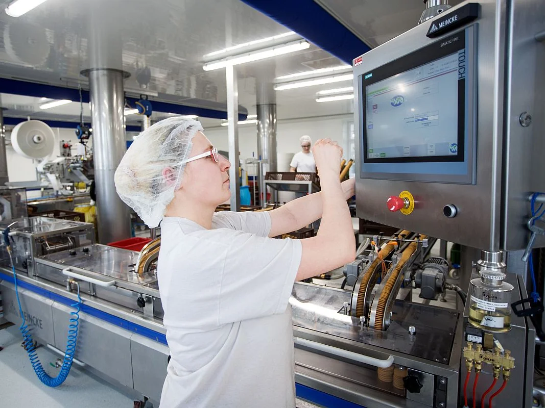 Eine Frau arbeitet an einer modernen Produktionsmaschine 