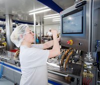 Eine Frau arbeitet an einer modernen Produktionsmaschine 