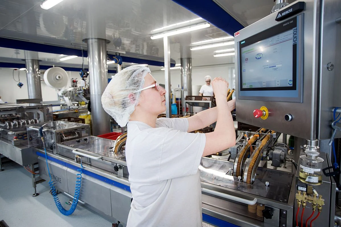 Eine Frau arbeitet an einer modernen Produktionsmaschine 
