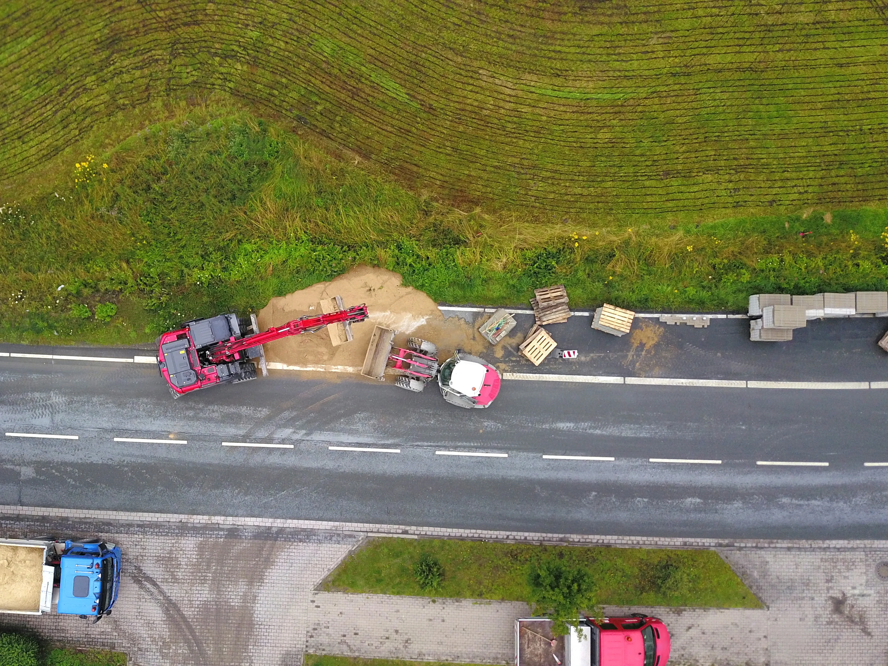 Neben einer Straße wird ein Radweg gebaut. Man sieht Baustellenfahrzeuge. 