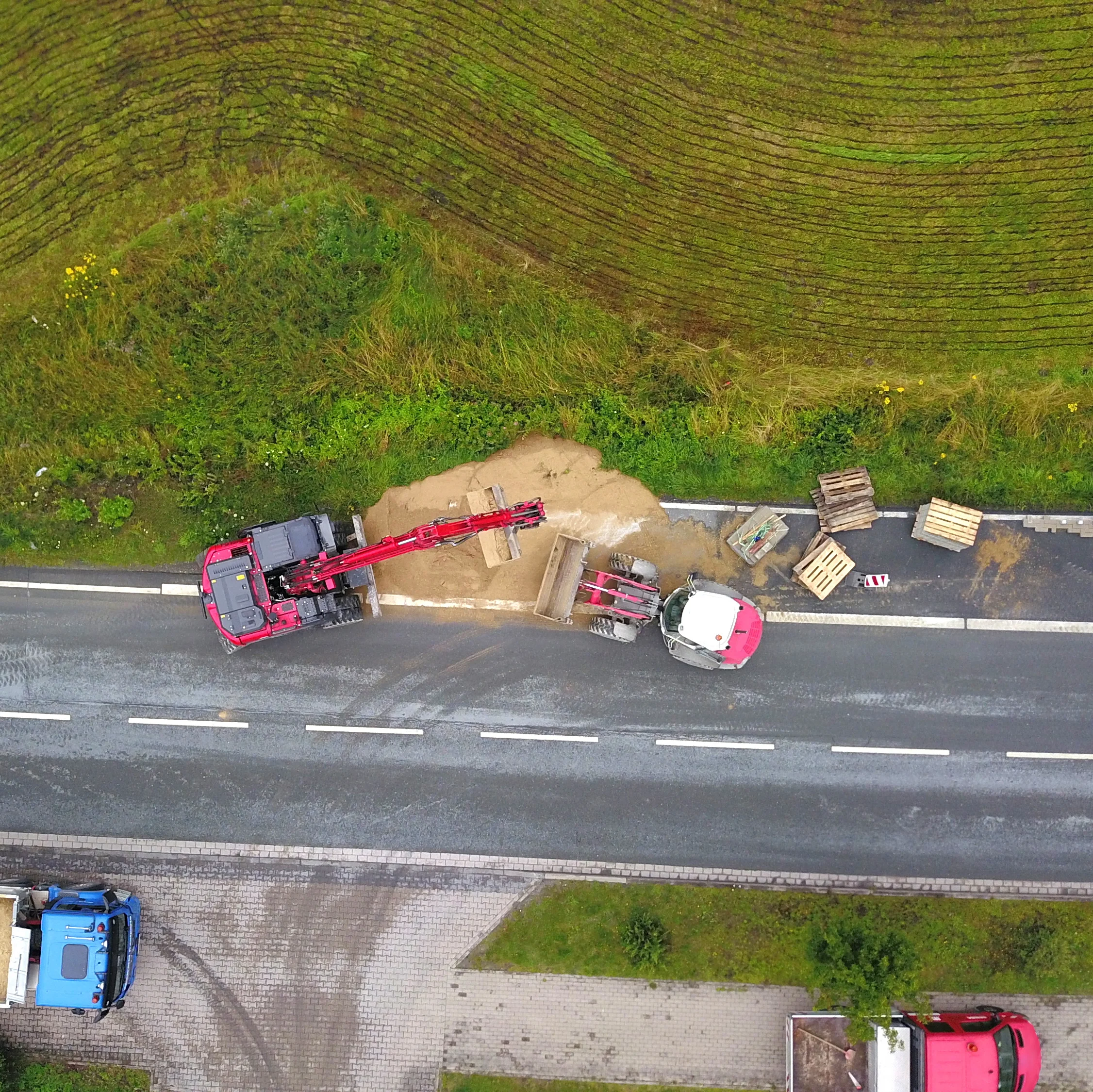 Neben einer Straße wird ein Radweg gebaut. Man sieht Baustellenfahrzeuge. 