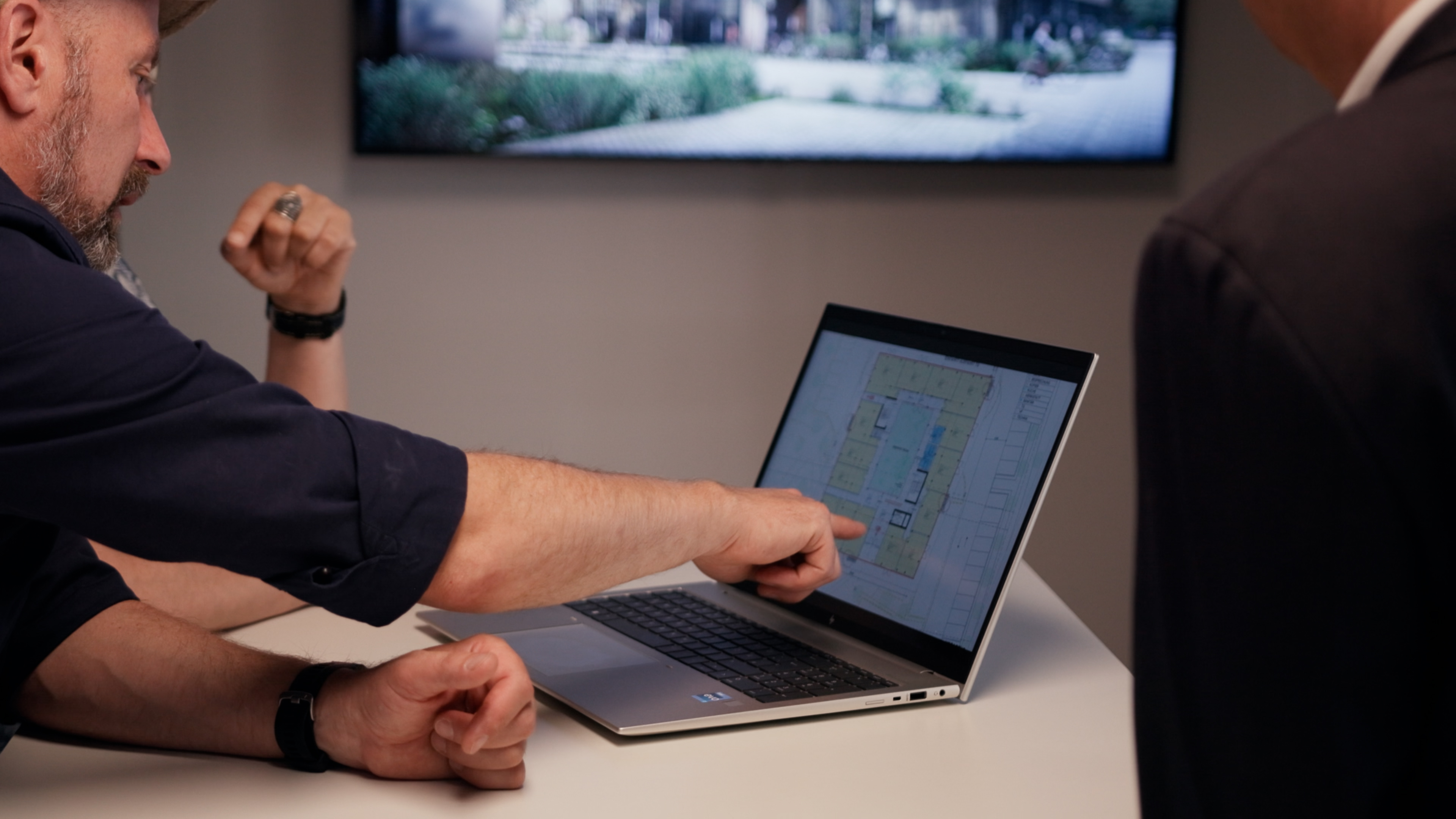 Drei Personen arbeiten zusammen an einem Laptop